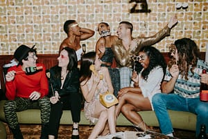 Group of friends enjoying a lively New Year's Eve party with laughter and festive decorations.
