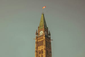 a tall clock tower with a flag on top