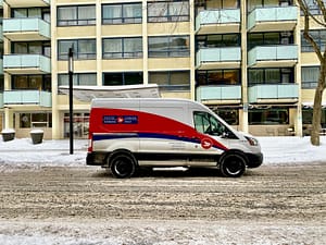 blue and white van parked near white concrete building during daytime