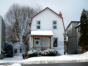 white and brown wooden house near bare trees during daytime