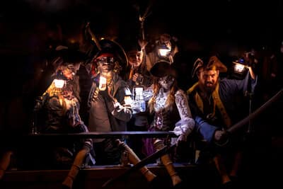 Costumed pirate actors with haunting makeup and lanterns pose dramatically aboard the haunted ship during Escape the Ghost Ship, an immersive escape room adventure in Ontario. Not your average cruise — pirates, suspects, and a sunset to die for. (CNW Group/Pirate Life Theatre)